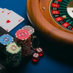 Pokerikortteja, pelimerkkejä, ruletti ja tietokone yhdistettynä rahapeliteemaan